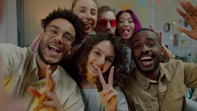 Portrait of happy multiethnic friends taking selfie indoors at home enjoying party together. Modern technology and friendship concept.