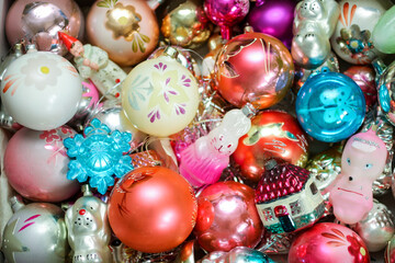 Different colorful Christmas toys (hare, house, ball, dog, snowflake) in a box. New year decorations, celebration. Top view