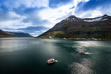 Two cruise ship life boats tendering passengers to the town of Seydisfjordur in Iceland. A view of...
