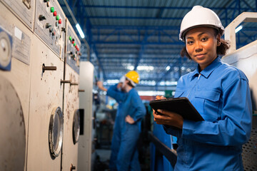 African American Young woman worker  in protective uniform operating machine at factory Industrial.People working in industry.Portrait of Female  Engineer at work place.