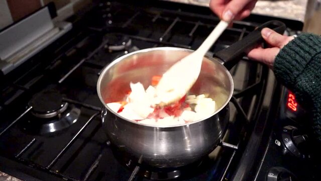 Slow motion stiring cooking food on a hob