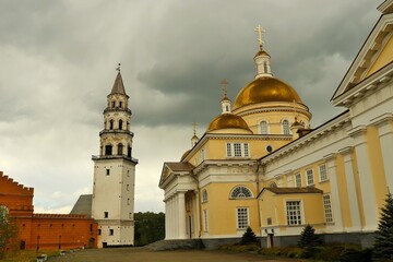 Fototapeta na wymiar Cloudy day, Orthodox church and old factory tower