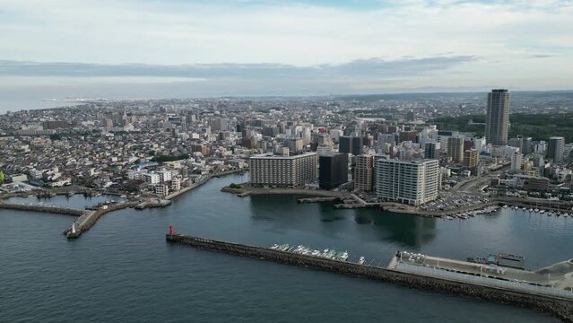 Slow pullback and rise over water with Akashi City harbor in background