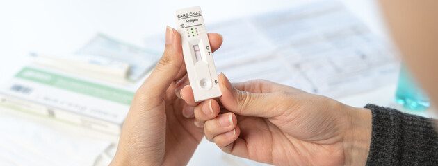 Close up of person reading result coronavirus test kit at home