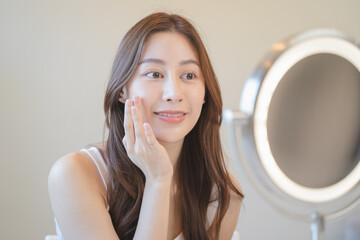Close up young beautiful asian woman looking at mirror at home