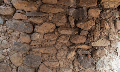 Rock or stone wall bricks pasted with mud. Wall texture and background.