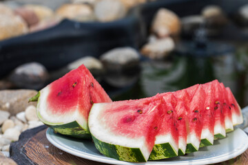 Fresh and juicy watermelon on a platter is cut into even slices. - 515006952