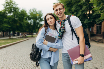 Beautiful happy couple summer portrait. Young joyful smiling woman and man in a city. Love, travel, tourism, students concept