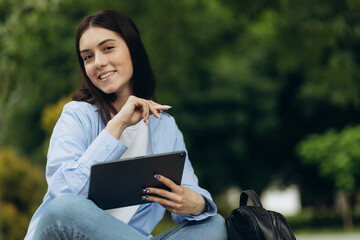 Fototapeta premium closeup of happy young girl in using tablet pc in the park