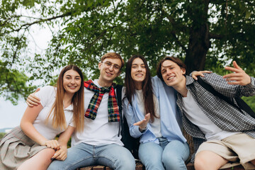Cheerful students sitting on a park bench. College Learning Concept