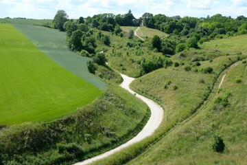 Beautiful view with a winding road between green fields from the early medieval settlement Stradow - the largest settlement in Poland, Ponidzie, Swietokrzyskie