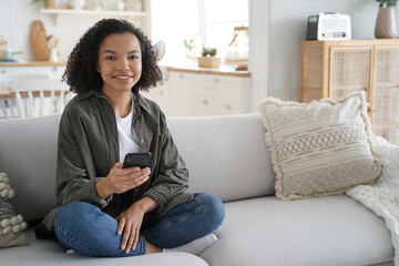 Obraz premium Young hispanic woman is browsing social media. Online book reading. Lazy weekend morning.
