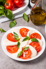Close-up photo of caprese salad with ripe tomatoes, basil, buffalo mozzarella cheese. Italian and Mediterranean food concept. Fresh and healthy organic meal. Starter and antipasti. 