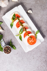 Close-up photo of caprese salad with ripe tomatoes, basil, buffalo mozzarella cheese. Italian and Mediterranean food concept. Fresh and healthy organic meal. Starter and antipasti. 
