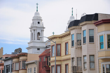 Fototapeta na wymiar A white church and victorian homes in a residential area within the city of San Francisco California.