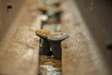 Bolts on a train track used by commuter and freight trains in a suburban town. 