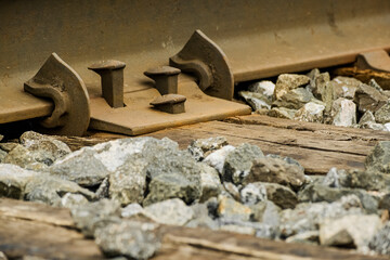 Bolts on a train track used by commuter and freight trains in a suburban town. 