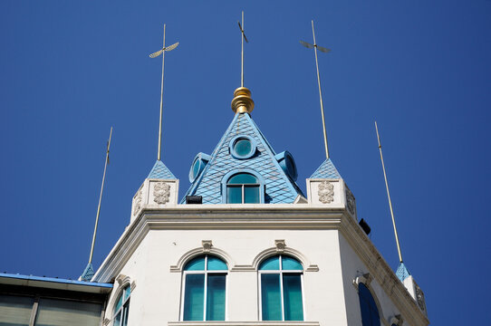 Gold lightning rods on top of a building against a blue sky on Zhongyang street in harbin China within Heilongjiang province.