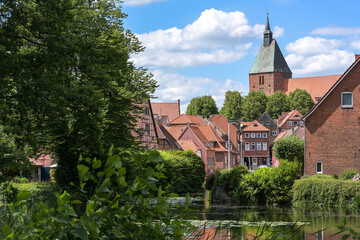 Old town with typical red brick buildings and St. Nikolai church of the medieval small city Moelln in Schleswig-Holstein, Germany, blue sky with clouds, copy space