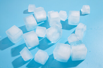 Many ice cubes on a blue background. Top view, flat lay