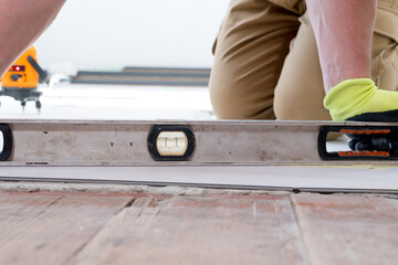 The master measures the level of the floor surface.