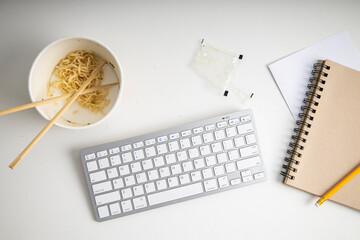 Chinese noodles in a paper bowl on a white background. Top view, fly lay