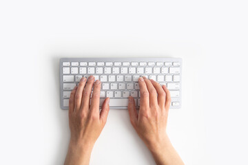 Female hands on the keyboard on a white background. Top view, flat lay - obrazy, fototapety, plakaty