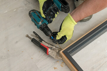 Drilling a hole in the door frame for a corner connection.