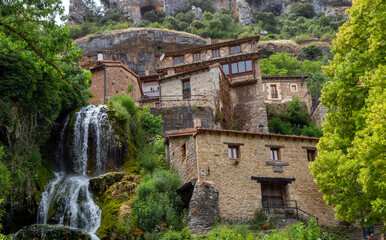 Fototapeta na wymiar Bonito pueblo. Un arroyo atraviesa la localidad en una cascada que desemboca en el río Ebro. Orbaneja del Castillo, Burgos, España.