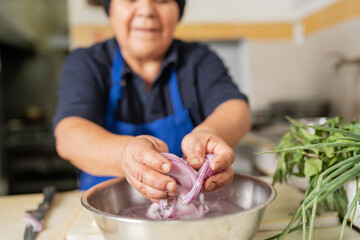Cook washing onion in a restaurant kitchen