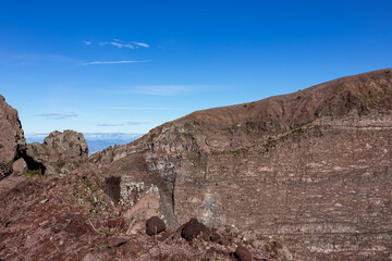 Fototapeta na wymiar Panoramic view on the edge of the active volcano crater of Mount Vesuvius, Province of Naples, Campania region, Southern Italy, Europe, EU. Volcanic landscape full of stones, ashes and solidified lava
