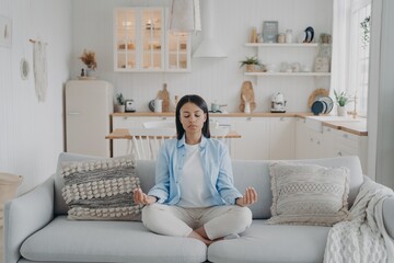 Peaceful mind, zen and concentration. Young hispanic woman is practicing yoga at home.