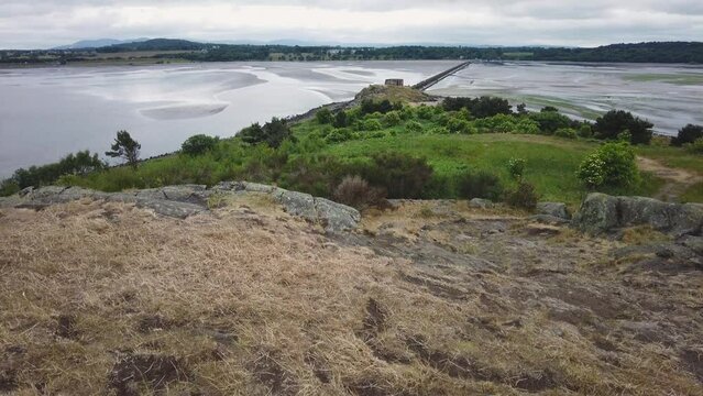 Cramond, Midlothian, Scotland &ndash; June 20 2022. Reveal shot of Cramond Island located in the Firth of the Forth on a dull and overcast day