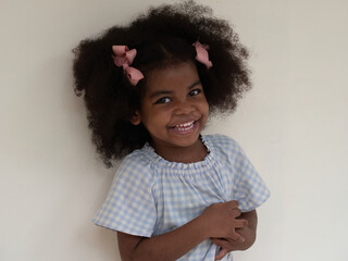 Portrait of cute little African girl with Afro hair style  laughing with happiness with white background.