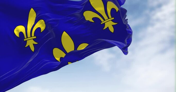 The flag of Ile de France region waving in the wind on a clear day