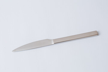 Stainless steel knife on white background, table knife, copy space