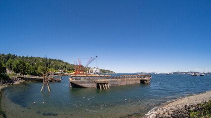 Barges and cranes afloat under summer sky