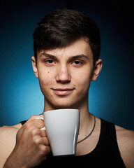 healthy athletic teenager on a dark background with a white mug in his hand, the concept of a healthy lifestyle