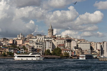Fototapeta na wymiar View of tour boats on Golden Horn area of Bosphorus in Istanbul. Galata tower and Beyoglu district are in the background. It is a sunny summer day.