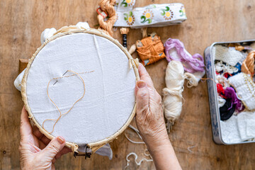 Traditional sewing concept. lady's hands surround a sewing frame.