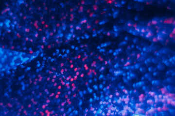 Blur sequin texture. Neon bokeh light. Futuristic radiance. Defocused ultraviolet navy blue pink color circles glow on dark black decorative abstract background.