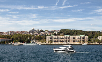 View of a yacht passing by historical palace on Bosphorus and European side of Istanbul. It is a sunny summer day. Beautiful scene. - 515035312