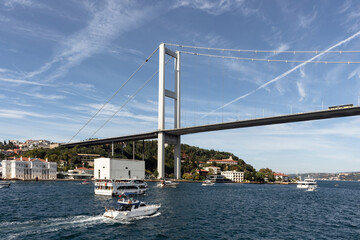 View of cruise tour boats on Bosphorus and bridge in Istanbul. It is a sunny summer day. Beautiful travel scene.