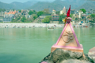 Ohm sign on a rock at the holy river Ganga near Rishikesh in India