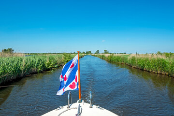 Cruising through National Park Alde Feanen in Friesland the Netherlands with the frisian flag