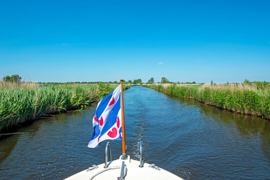 Cruising through National Park Alde Feanen in Friesland the Netherlands with the frisian flag