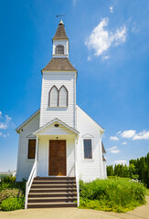 Beautiful traditional church in rural. Exterior of a Little White Country Church on a Sunny Day and blue sky background