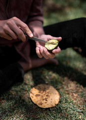 Close up of a young man cutting avocado for a tortilla during a hike
