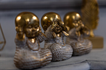 Three Wise little Buddha figurine in a row, Hear no evil, See no evil, Speak no evil, - Powered by Adobe