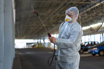 Worker wearing protective suit disinfection gear disinfect surface public place